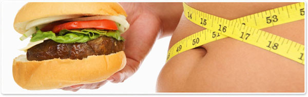 Person Measuring Waist While Holding a Hamburger